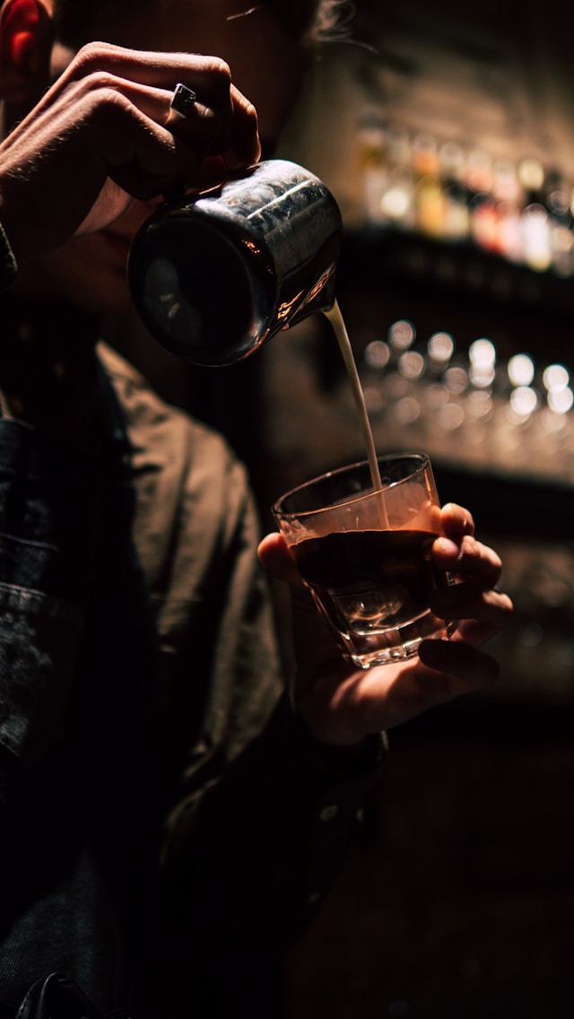 barista nalévá mléko do sklenice